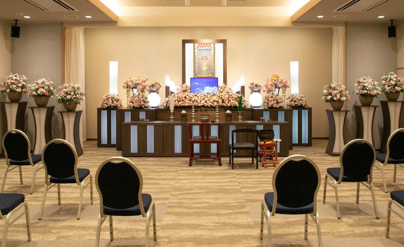 費用を抑えた家族葬や一日葬に最適な、シンプルで美しい生花祭壇と葬儀場の内観