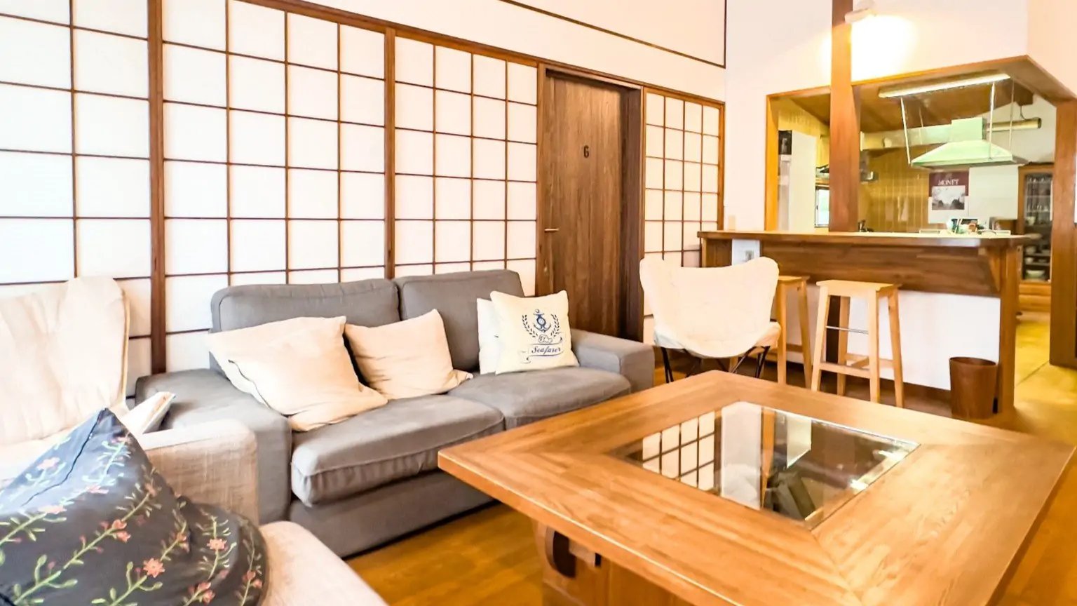 和室の畳とモダンなソファが調和した家具家電付きマンスリーマンションの内装（リビング・キッチン）